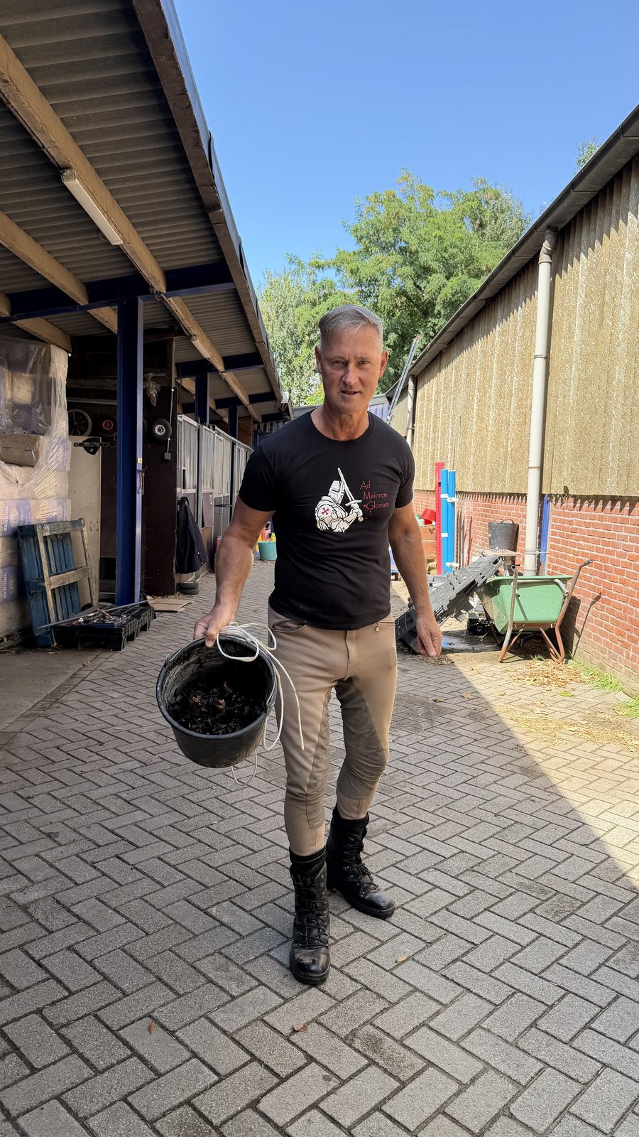 Deelnemer draagt een emmer met bladafval uit de goot
