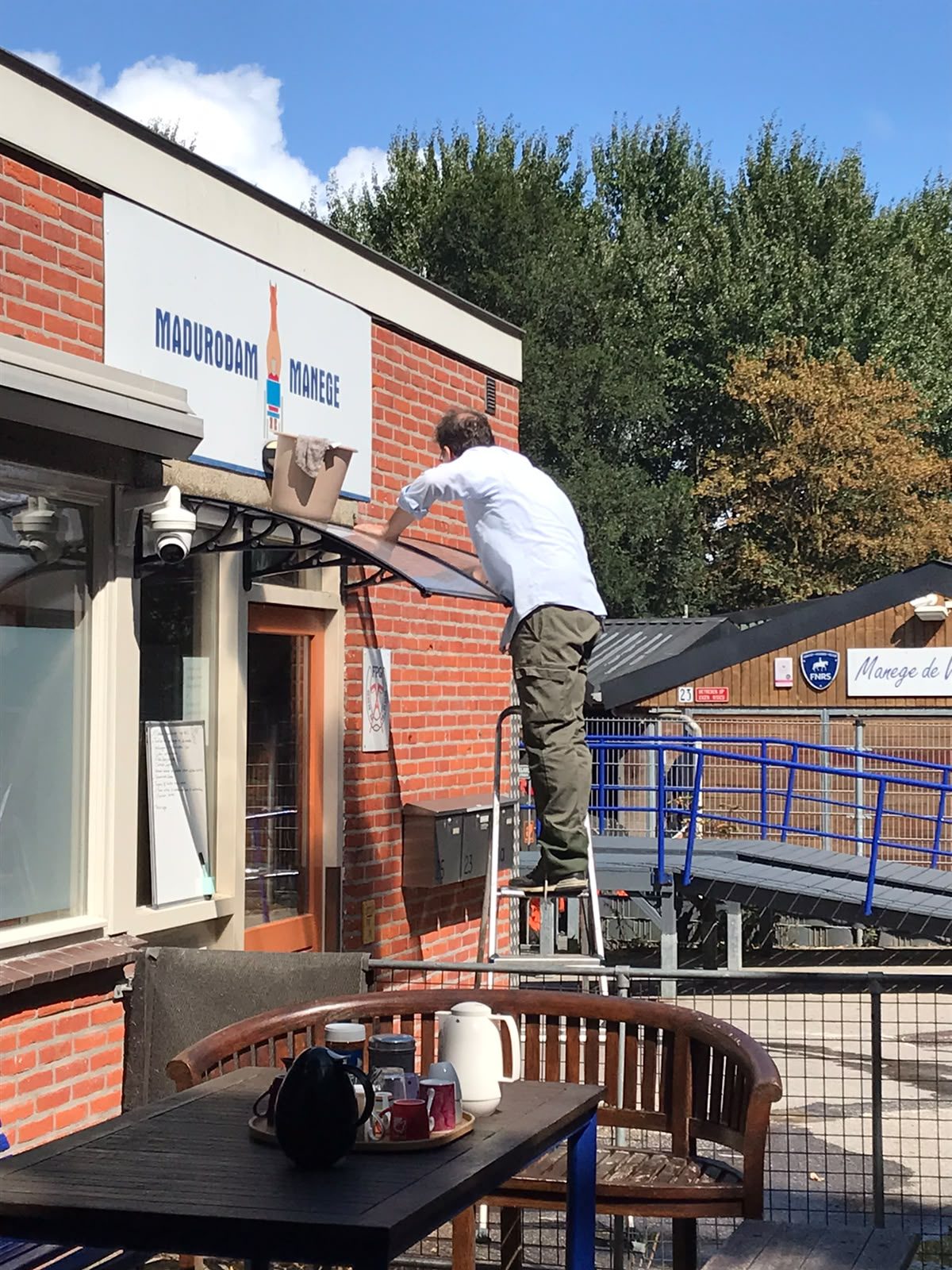 Deelnemer op een trapje bij de luifel van de entree